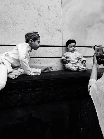 A mother takes a picture of her children at the Jama Masjid, a simple black and white scene that tells a universal story of family and memory-making.
