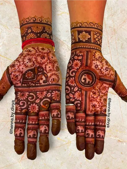 This design is a celebration of the majestic elephant. It features elephant motifs of various sizes, from the large one on the palm to the small procession on the fingers and wrist.