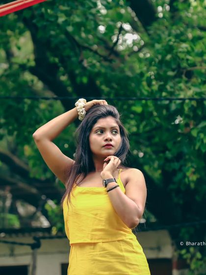 A portrait that captures a fleeting expression against a backdrop of trees, giving it a candid and spontaneous feel.