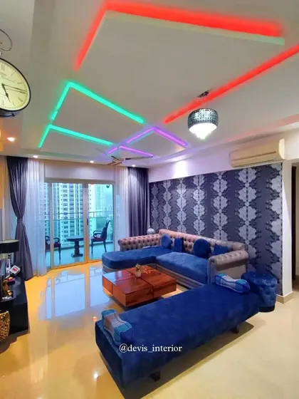 My work extends beyond the kitchen. This living room features custom cove lighting with adjustable colors to set any mood, complemented by a bold accent wall and a comfortable, stylish sectional sofa, creating a vibrant space for relaxation and entertainment.