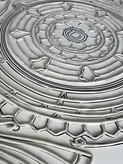 A close-up of the raw, textured base of the "Siddha Chakra" before painting. The lines are carefully drawn to guide the intricate details of the yantra.