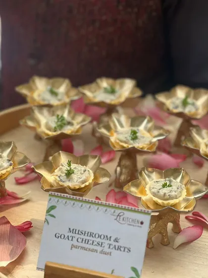 Elegant mushroom and goat cheese tarts served in beautiful golden lotus-shaped cups, finished with a dusting of parmesan.