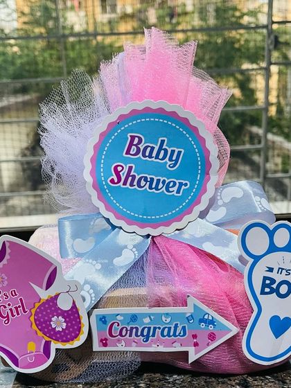 A closer look at a custom baby shower hamper. This gift includes a variety of baby-themed soaps like a sleeping baby, pram, milk bottle, and baby feet, all made with gentle ingredients.