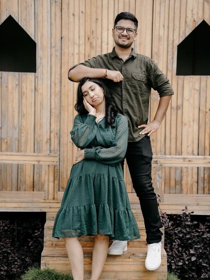 A funny and cute pose with the groom resting his arm on the bride's head, showcasing their playful dynamic.