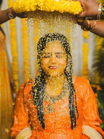 A beautiful shot of the turmeric water ritual. The background of marigold strings adds a traditional and festive touch to the entire Haldi ceremony.