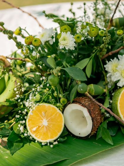 Another angle of the beautiful, fresh centerpiece with raw bananas, coconuts, and delicate flowers, showcasing the artistry involved in my event styling.
