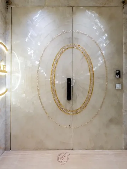 The play of light on the Selenite stone gives this entrance a natural luster. The custom-designed, backlit nameplate adds a personalized touch, making the entryway feel both grand and welcoming.