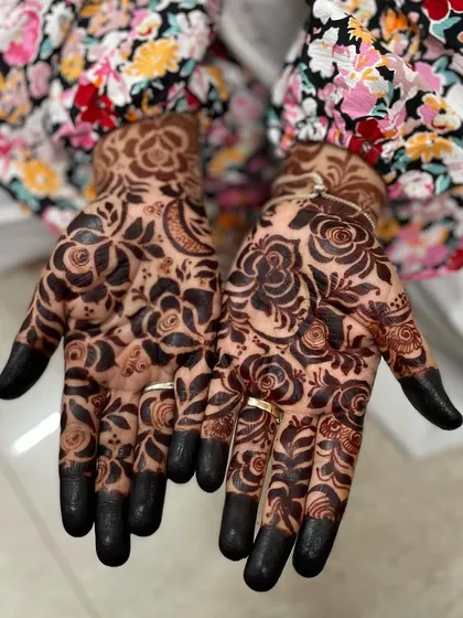 This beautiful mehendi is all about bold, dark florals. The contrast between the filled-in roses and the skin creates a striking and modern design, finished with classic dark fingertips.