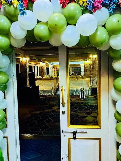 A welcoming entrance for a baby shower, featuring a balloon arch in green and white. It's a simple and cheerful way to greet guests and set the tone for the celebration inside.