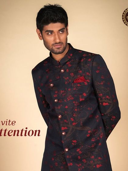 Invite attention with this dark navy Indo-Western jacket featuring a bold red floral print. A unique piece for a fashion-forward groom.