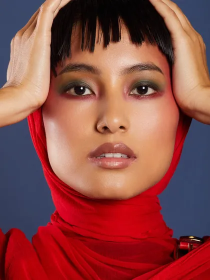 A striking look with a red headscarf, featuring a blend of green and red eyeshadow for a bold, high-contrast effect.