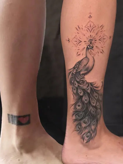 Even a small, dark tattoo can be completely hidden. I designed this elegant peacock to flow with the ankle, turning an old memory into a beautiful, detailed masterpiece.