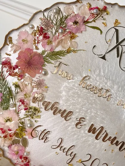 A close-up of the floral arrangement and gold lettering on the standing ring platter.