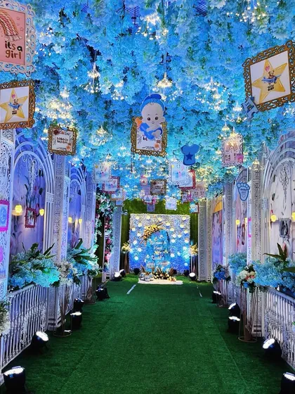We transformed this venue into a dreamy celestial wonderland. The entrance corridor is lined with ornate white arches and a ceiling filled with blue florals, twinkling fairy lights, and hanging picture frames, creating an immersive "twinkle twinkle little star" experience.