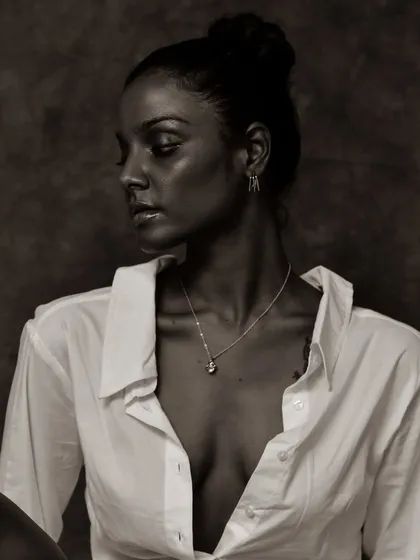 A soft and pensive black and white portrait. The lighting is gentle and creates a beautiful, classic mood.