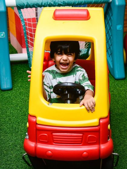 Beep beep! A joyful shout from the driver's seat of our classic toy car, a favorite for toddlers exploring the play area.