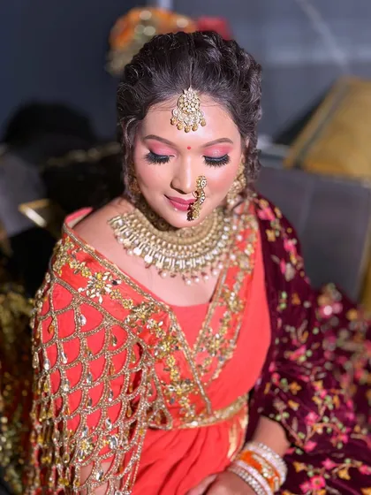 A vibrant look with bright pink eyeshadow and a beautiful red and gold outfit, perfect for a bride who loves color.