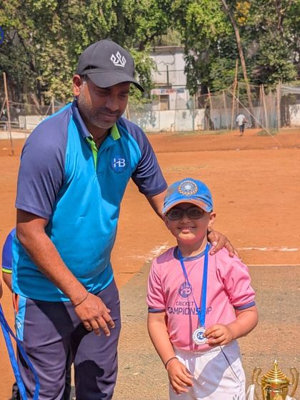 A proud young player receives their medal from a coach, a simple but powerful moment of acknowledgment for their hard work.