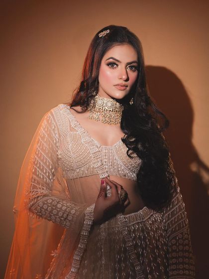 A beautiful shoot featuring a soft glam look. The makeup is focused on a flawless base and defined eyes, perfect for this ethereal, white lehenga.