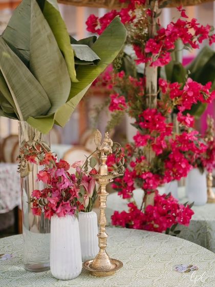 An Olive Bloom Haldi setup featuring lush banana leaves, vibrant bougainvillea, and traditional brass lamps. The rustic, natural decor created a warm and inviting atmosphere for this celebration in Udaipur.
