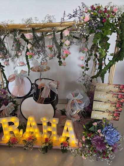 This view highlights the personalized floral signs and the beautiful mix of flowers surrounding the drum set hamper.