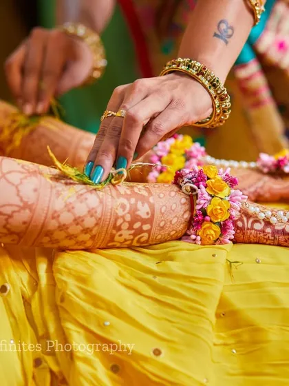 A detailed shot of floral jewelry being tied onto the bride's arm during her Haldi ceremony. I focus on these small, meaningful details and rituals that are part of the day.