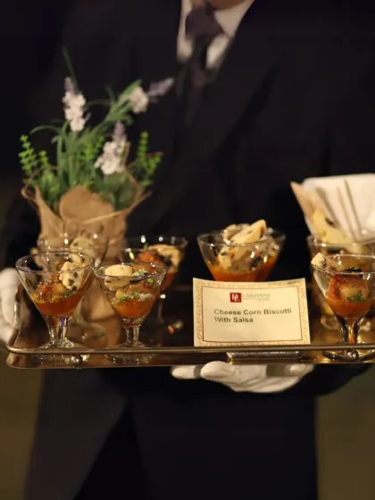 Impeccable service is the cornerstone of our hospitality. Our professionally trained staff ensures every guest feels attended to, presenting elegant appetisers like these cheese corn biscotti with salsa with grace and precision.