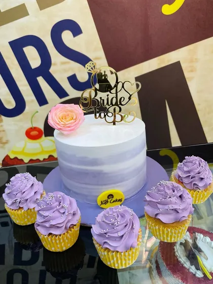 We create coordinated dessert tables for your events. This set for a bridal shower includes a central lavender ombre cake with a "Bride to Be" topper, perfectly matched with a half-dozen frosted cupcakes for guests to enjoy.