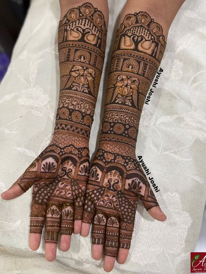 The full engagement mehendi, with bands of swans, parrots, and elephants, creating a design that is both traditional and full of life.
