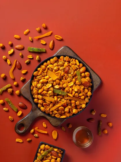 A Khatta Meetha mix for Sartaj Sweets. The deep red background enhances the visual appeal of the snack for its packaging.