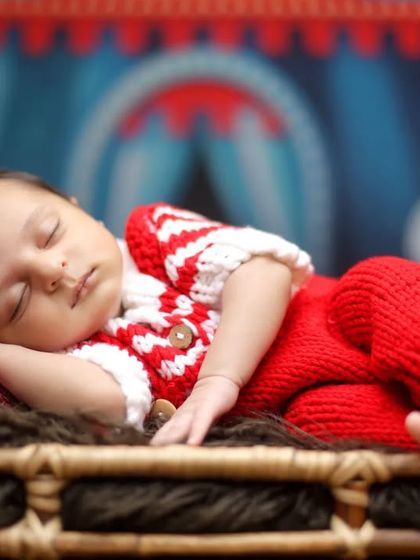 A close-up of the star of the show. This shot focuses on the sleeping baby in a red knit outfit, perfectly complementing the circus theme's bright colors.