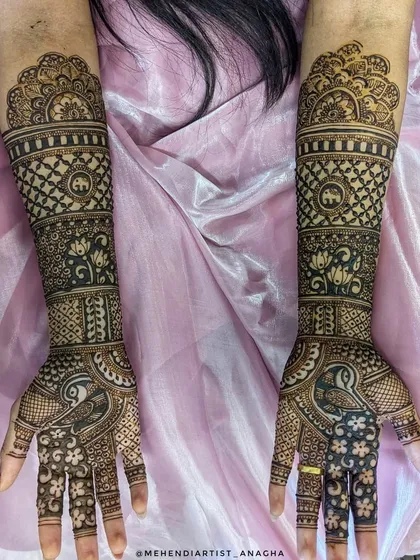 This full-arm bridal design incorporates traditional Indian motifs like elephants and lotuses. The intricate jaali (net) pattern and bold peacock figures create a balanced and beautiful look.