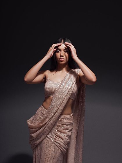 A powerful portrait focusing on the upper body. The model's pose and the dramatic studio lighting highlight the texture of the sequined fabric and create a high-fashion mood.