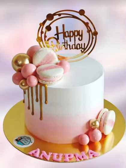 Another take on the modern macaron cake, this one with a gold drip and a cascade of pink chocolate balls.