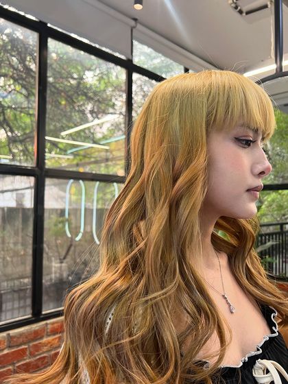 A close-up profile of the sunset hair color, showing the beautiful blend of shades and the client's edgy bangs.