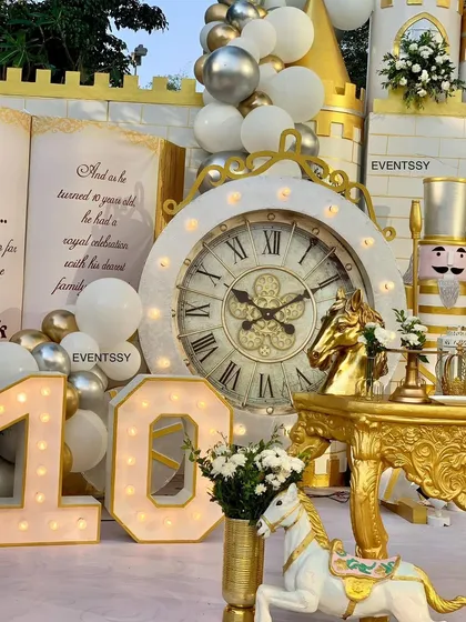 A close-up of the giant clock prop and marquee number "10" from the royal prince theme. These large-scale props add to the fairytale atmosphere and are great for photos.
