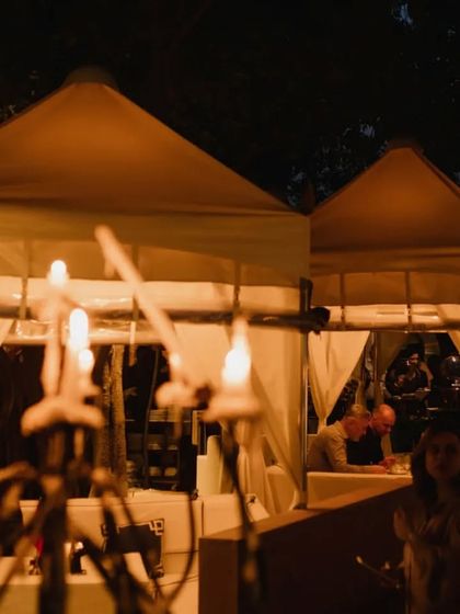 A view of the event at night, with guests seated in the softly lit cabanas, creating a magical and festive atmosphere.
