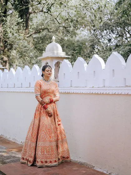A wide shot of the bride in a beautiful palace-like setting, looking serene and elegant.