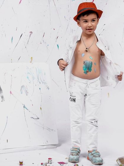 The little artist shows off his paint-splattered tummy during our messy and fun painter-themed shoot.