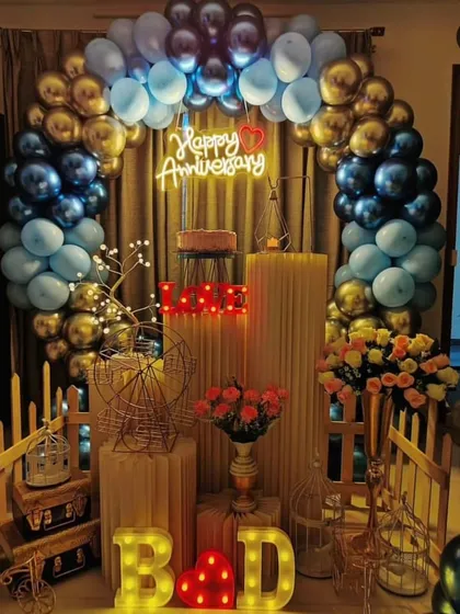 I designed this elegant anniversary decoration with a striking blue and gold balloon arch. The setup is personalized with the couple's initials in marquee letters and a romantic "Happy Anniversary" neon sign, creating a perfect photo backdrop for their special day.
