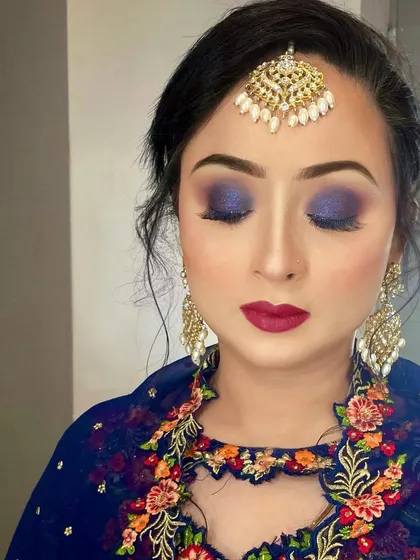 A beautiful demonstration of a blue smokey eye paired with a bold red lip, a classic combination for evening events and receptions.