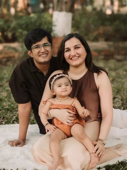 A relaxed and happy family enjoying a picnic setup during their outdoor photoshoot.