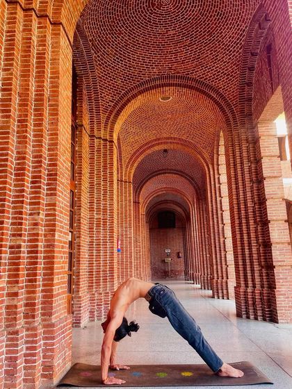 Camatkarasana (Wild Thing) in a beautiful architectural setting. This pose is an expression of joy, opening the heart and celebrating the body's potential.