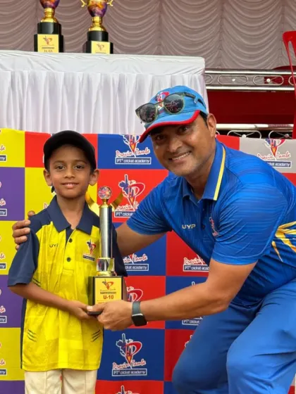 A coach shares a happy moment with a U-10 award winner, showcasing the supportive and encouraging atmosphere at our academy.