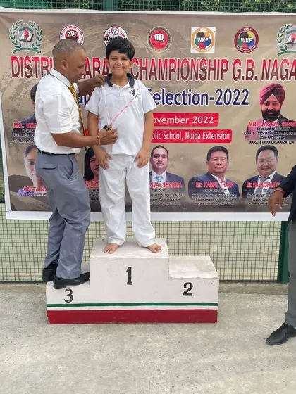 Devansh Goel stands on the first-place podium after winning gold at the District Karate Championship.