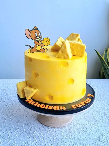 A full view of the Jerry and cheese cake on its stand.