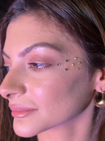 A scattered placement of small rhinestones under the eye for a subtle sparkle. This is a very popular and trendy look that works for any party.