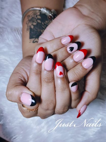 A playful and modern design on almond-shaped nails. This set features a mix of red and black tips with hand-painted heart and spade symbols.