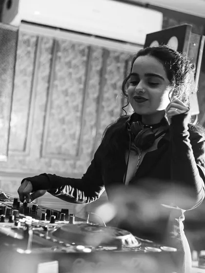 A black and white shot of me smiling at the decks. It captures a moment of pure happiness and connection with the music and the crowd.