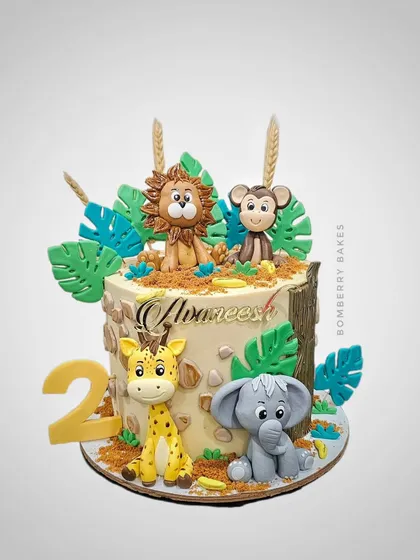 A detailed jungle safari cake for a second birthday, featuring handmade 3D fondant animals. I focus on creating cute, characterful figures like the lion, monkey, giraffe, and elephant to delight the little ones.